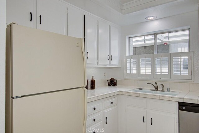 2399 Via Mariposa W Unit 2E, Laguna Woods, CA 92637 - kitchen featuring freestanding refrigerator, stainless steel dishwasher, tile counters, white cabinetry, and crown molding