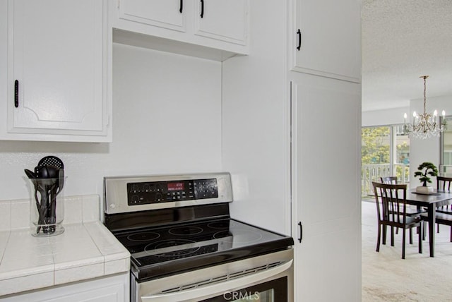 2399 Via Mariposa W Unit 2E, Laguna Woods, CA 92637 - kitchen featuring electric stove, tile counters, a chandelier, and white cabinetry