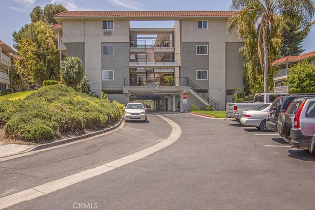 2399 Via Mariposa W Unit 2E, Laguna Woods, CA 92637 - view of property featuring uncovered parking and stairs