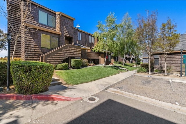 surrounding community featuring a yard and uncovered parking