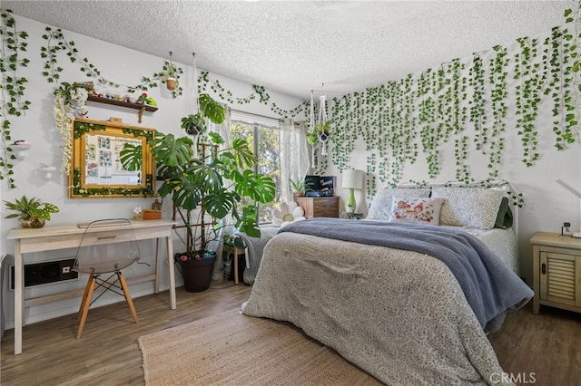 bedroom featuring a textured ceiling and wood finished floors