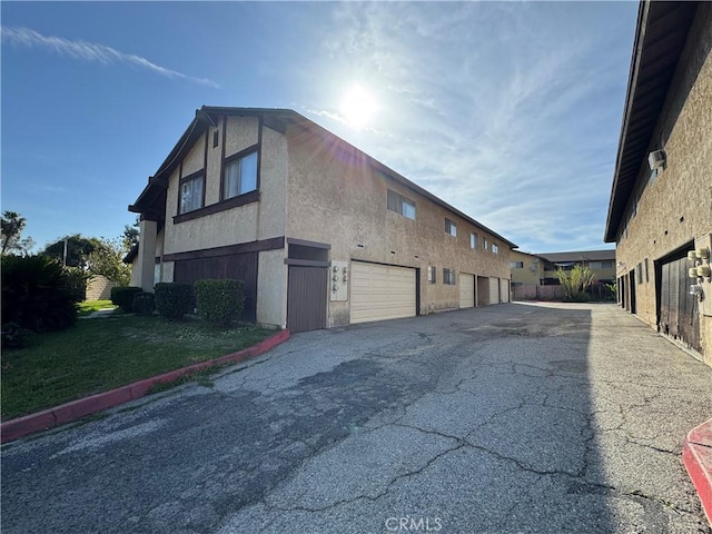 2453 S Ridgewood Dr, West Covina, CA 91792 - view of side of property featuring stucco siding and driveway
