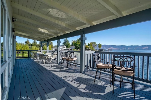 deck with outdoor dining area and a mountain view