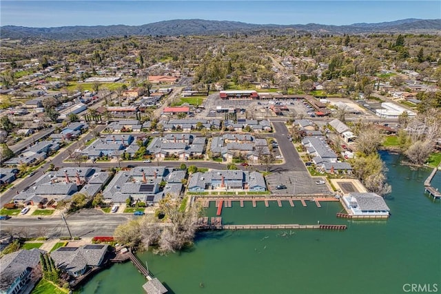 drone / aerial view with a water and mountain view and a residential view
