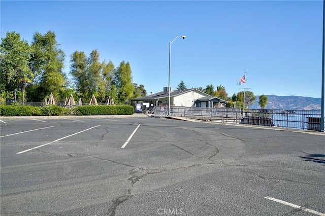 uncovered parking lot with a mountain view and fence