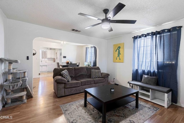 510 Decatur St, Bakersfield, CA 93308 - living area featuring arched walkways, visible vents, a textured ceiling, and ceiling fan