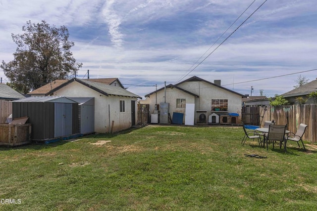 510 Decatur St, Bakersfield, CA 93308 - rear view of property with a shed, a yard, stucco siding, an outdoor structure, and fence