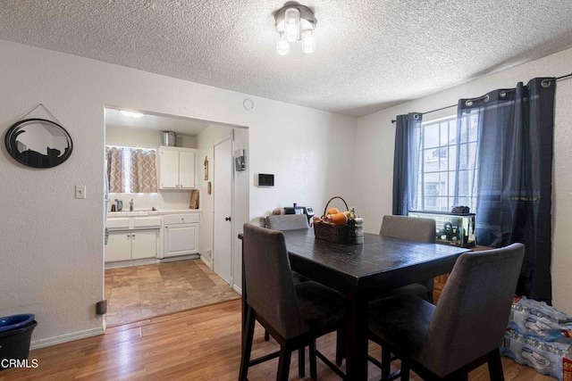 510 Decatur St, Bakersfield, CA 93308 - dining space featuring light wood-style flooring, baseboards, a textured wall, and a textured ceiling