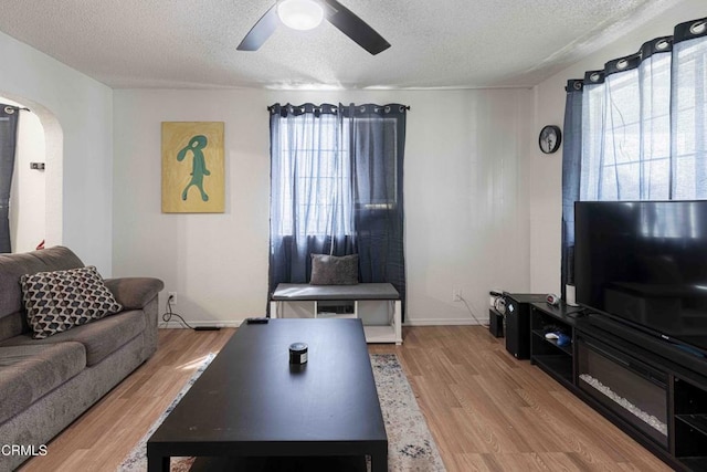 510 Decatur St, Bakersfield, CA 93308 - living area with ceiling fan, light wood-type flooring, arched walkways, and a textured ceiling