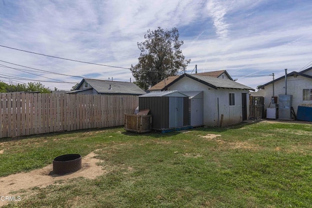 510 Decatur St, Bakersfield, CA 93308 - view of yard featuring a shed, a fire pit, a fenced backyard, and an outbuilding