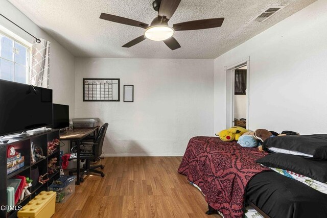 510 Decatur St, Bakersfield, CA 93308 - bedroom with a textured ceiling, wood finished floors, a ceiling fan, and visible vents