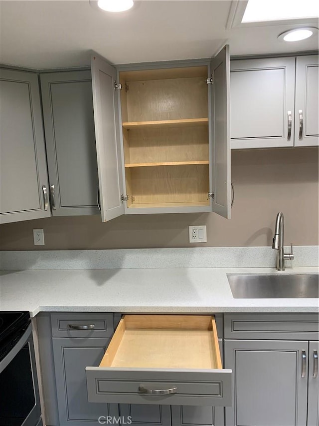 1441 Homewood Rd Unit M5-96B, Seal Beach, CA 90740 - kitchen with gray cabinets, a sink, light countertops, and range with electric cooktop