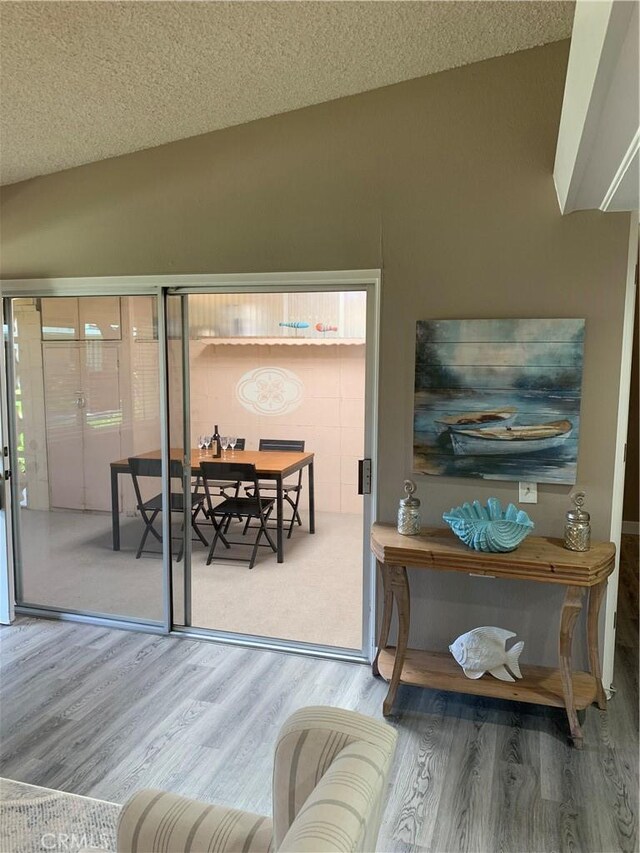 1441 Homewood Rd Unit M5-96B, Seal Beach, CA 90740 - living room featuring wood finished floors, vaulted ceiling, and a textured ceiling