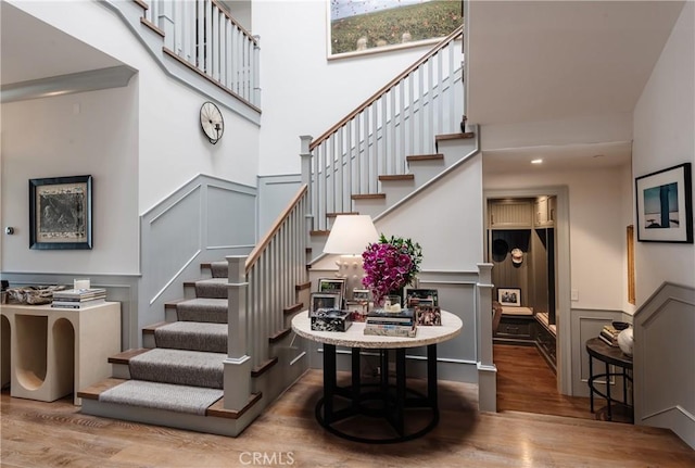 617 Anderson St, Manhattan Beach, CA 90266 - stairs with a decorative wall, wood finished floors, a high ceiling, and a wainscoted wall