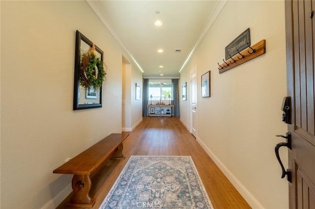 doorway with recessed lighting, light wood finished floors, baseboards, and ornamental molding