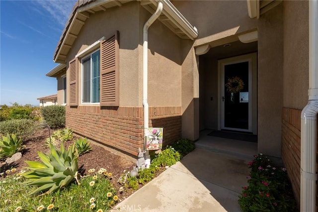 view of property exterior featuring brick siding and stucco siding