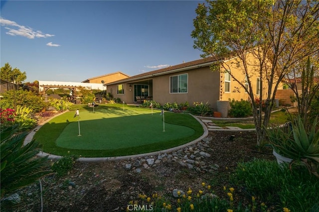 back of property featuring stucco siding and fence