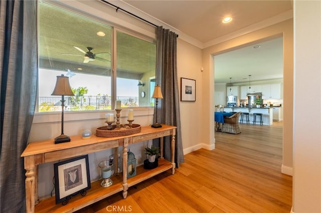 doorway to outside with recessed lighting, wood finished floors, a ceiling fan, crown molding, and baseboards