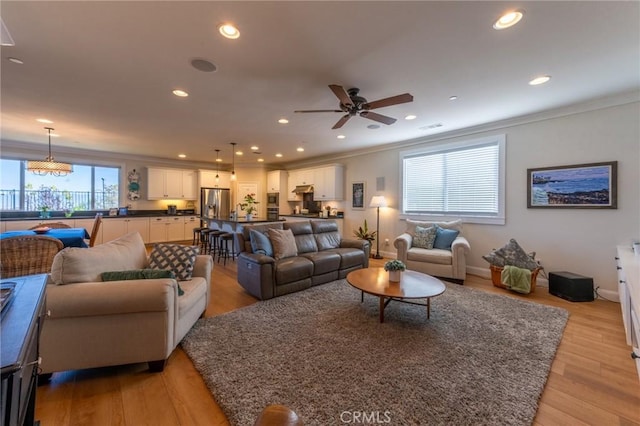 living area featuring light wood-type flooring, recessed lighting, and crown molding