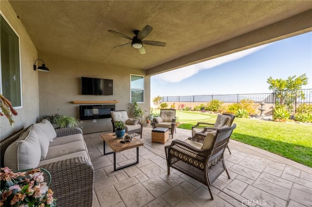 view of patio / terrace with an outdoor hangout area, fence, and ceiling fan