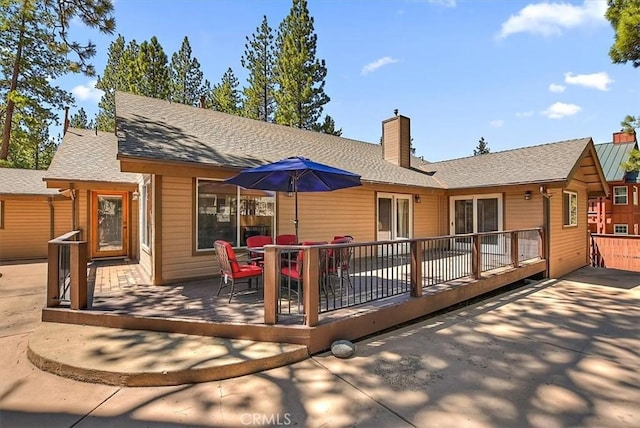 105 Olympic Dr, Big Bear Lake, CA 92315 - back of house featuring a shingled roof, a deck, and a chimney