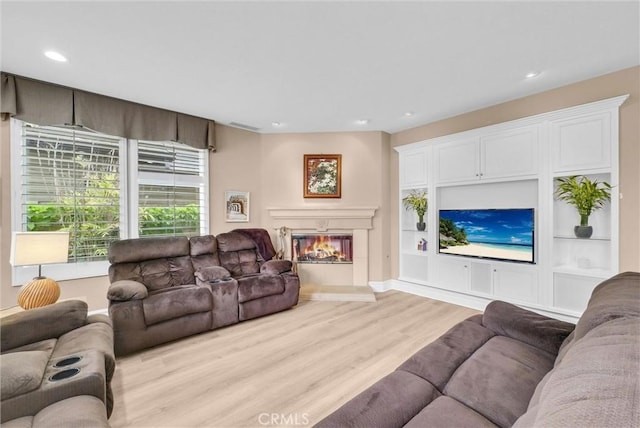 2 Aquila Way, Coto De Caza, CA 92679 - living area with light wood-style flooring, a glass covered fireplace, recessed lighting, and baseboards