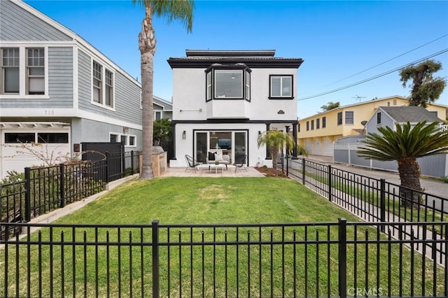 rear view of house with a patio, a fenced backyard, stucco siding, and a lawn