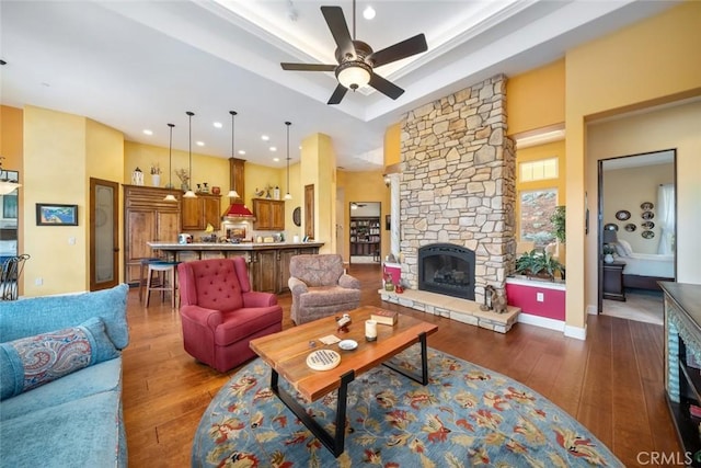 162 Valley View Pl, Arroyo Grande, CA 93420 - living room featuring a tray ceiling, a ceiling fan, hardwood / wood-style flooring, a stone fireplace, and recessed lighting