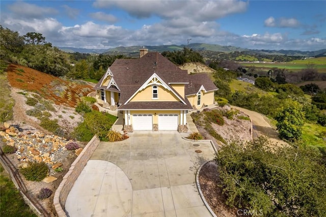 162 Valley View Pl, Arroyo Grande, CA 93420 - view of front facade with driveway, stucco siding, a chimney, an attached garage, and a mountain view