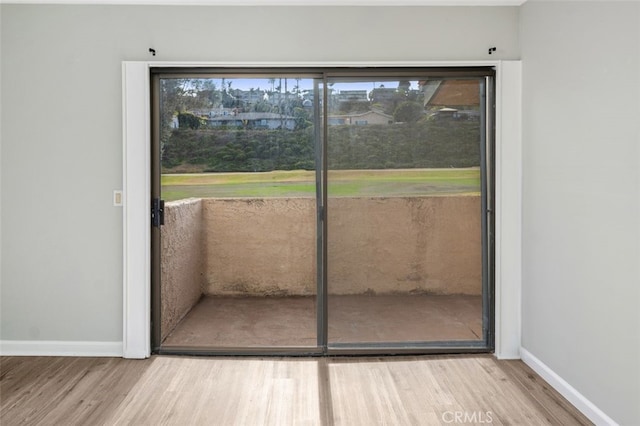 doorway to outside with baseboards and wood finished floors