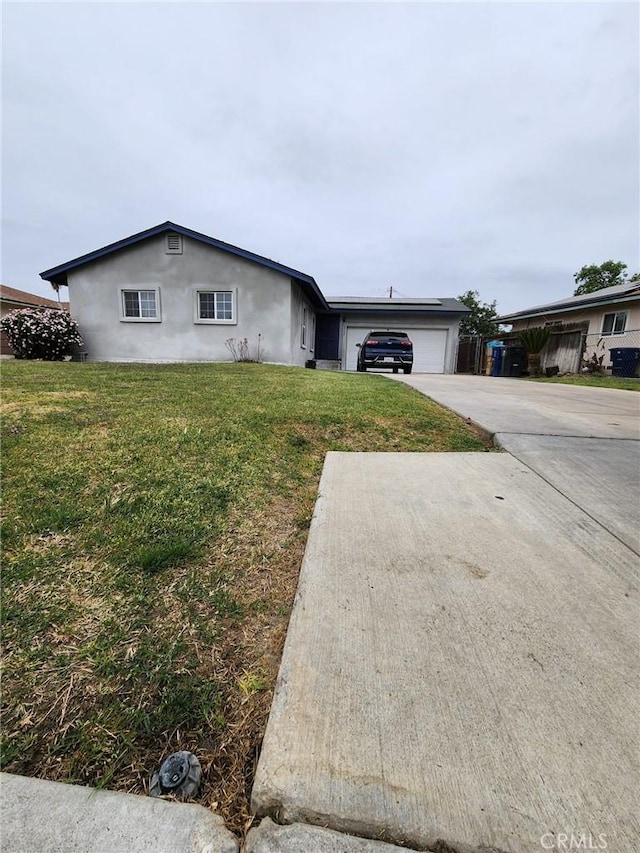 ranch-style house with concrete driveway, stucco siding, a front yard, and a garage