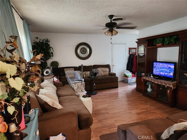living room with wood finished floors, a textured ceiling, and ceiling fan