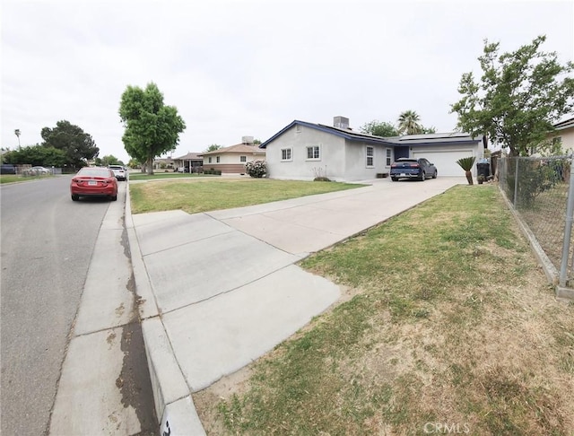 view of front of property with concrete driveway, central air condition unit, fence, a front yard, and a garage