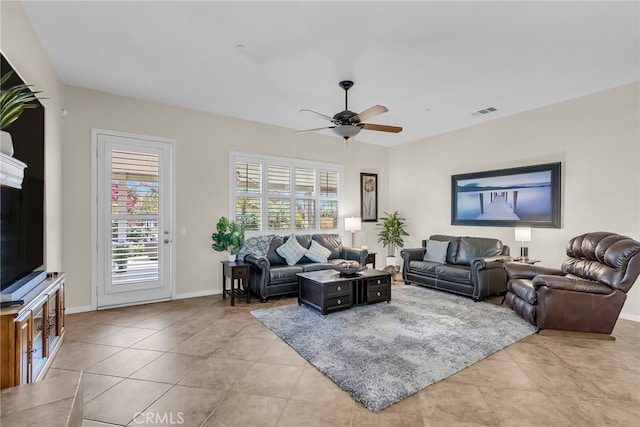 living room with light tile patterned flooring, baseboards, a ceiling fan, and visible vents