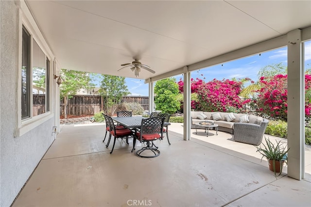 view of patio featuring outdoor dining area, outdoor lounge area, fence, and ceiling fan