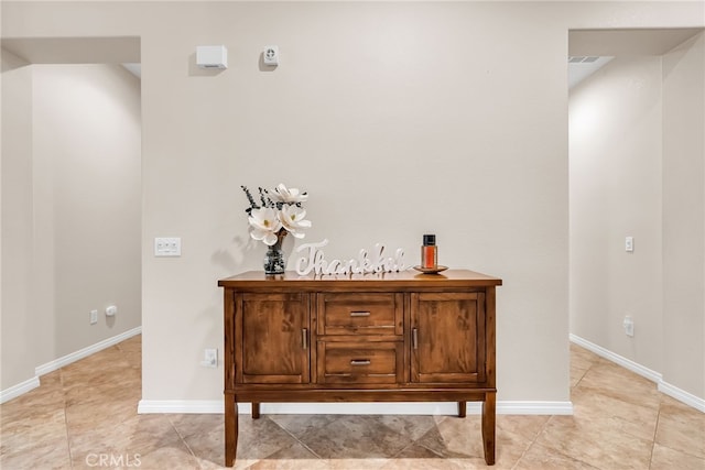 interior space with light tile patterned flooring, baseboards, and visible vents