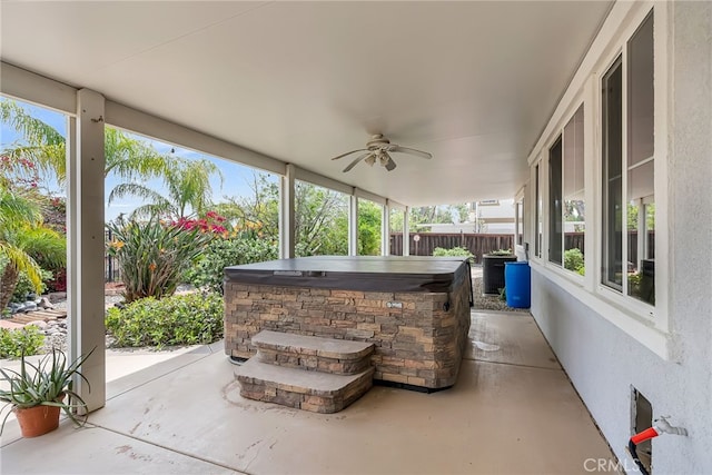 view of patio with ceiling fan, fence, and a hot tub