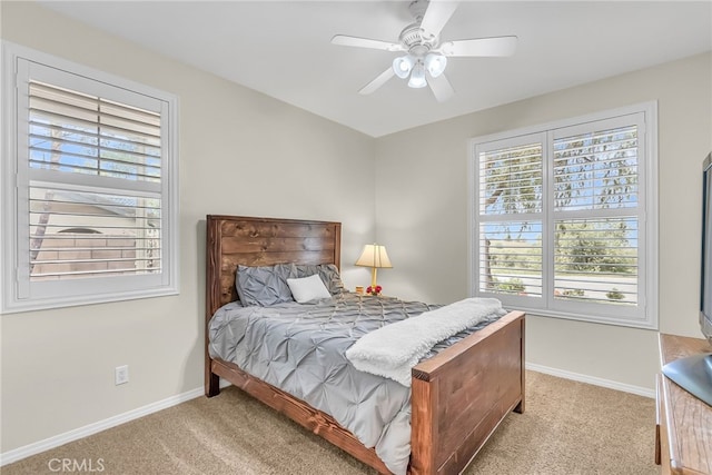 carpeted bedroom with baseboards, multiple windows, and a ceiling fan