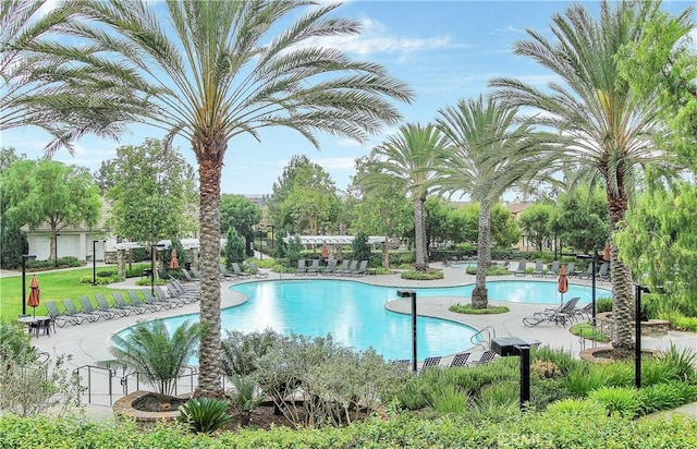 pool with a patio area and fence