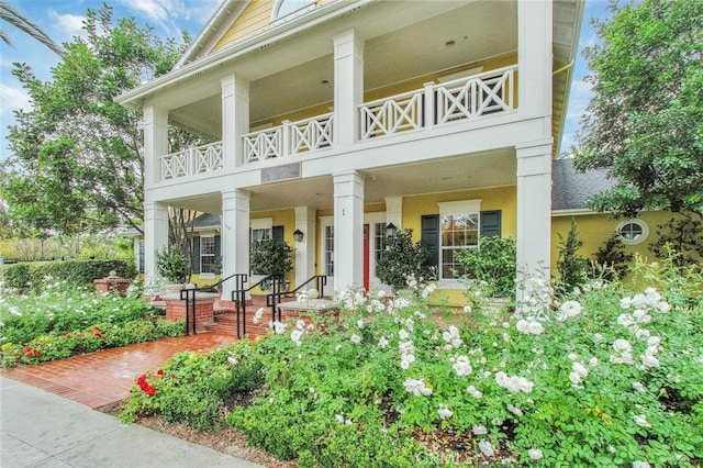 back of property with a porch and a balcony