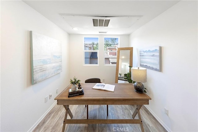 home office with visible vents, light wood-style flooring, and baseboards