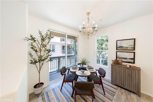 dining room featuring light wood-type flooring, radiator heating unit, a notable chandelier, and a wealth of natural light