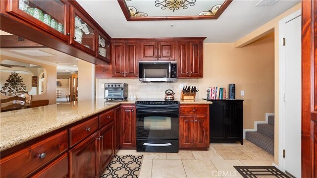 4176 Goss Rd, Phelan, CA 92371 - kitchen featuring stainless steel microwave, black / electric stove, reddish brown cabinets, and decorative backsplash