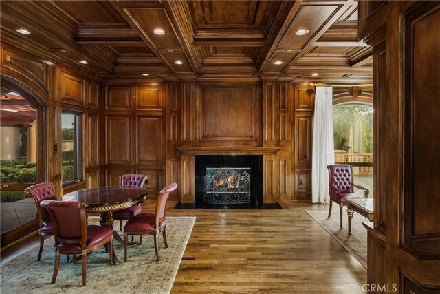 living area featuring wooden walls, crown molding, coffered ceiling, and wooden ceiling