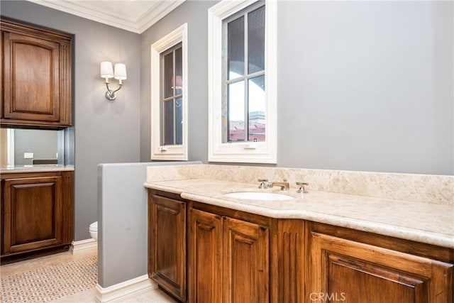 bathroom featuring toilet, ornamental molding, and vanity