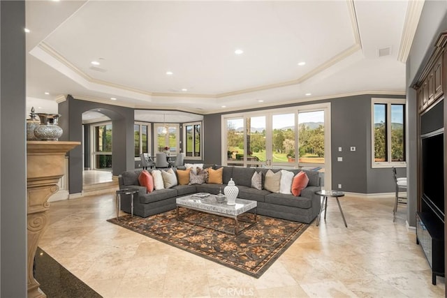 living area with visible vents, a healthy amount of sunlight, and a tray ceiling