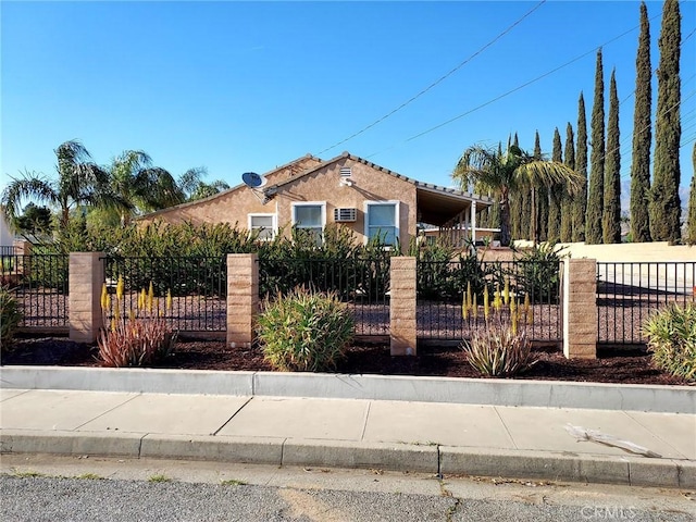 view of front facade featuring stucco siding and a fenced front yard