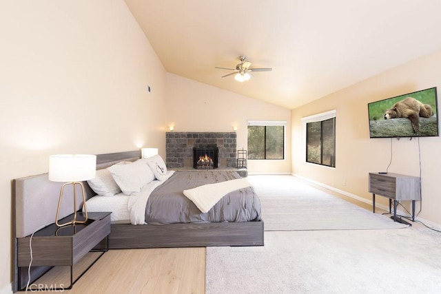 bedroom with baseboards, a lit fireplace, ceiling fan, and lofted ceiling