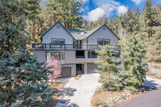 2405 Cedarwood Dr, Pine Mountain Club, CA 93222 - chalet / cabin with a balcony, an attached garage, driveway, and stone siding