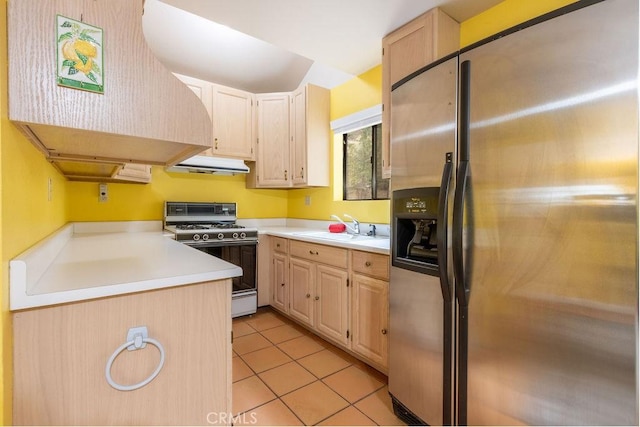 kitchen featuring a sink, gas stove, stainless steel fridge with ice dispenser, under cabinet range hood, and custom exhaust hood